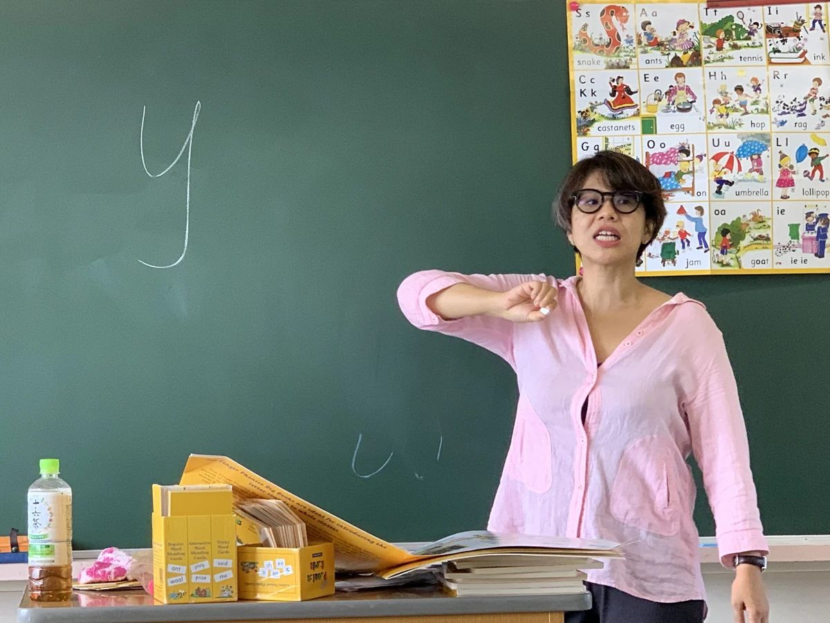 Atsuko Maruyama demonstrating a phonics action during a lesson at a private secondary school